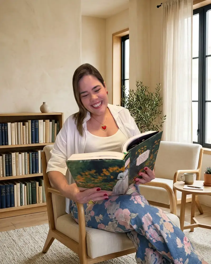 Daniella Xavier lendo em uma poltrona, sorrindo